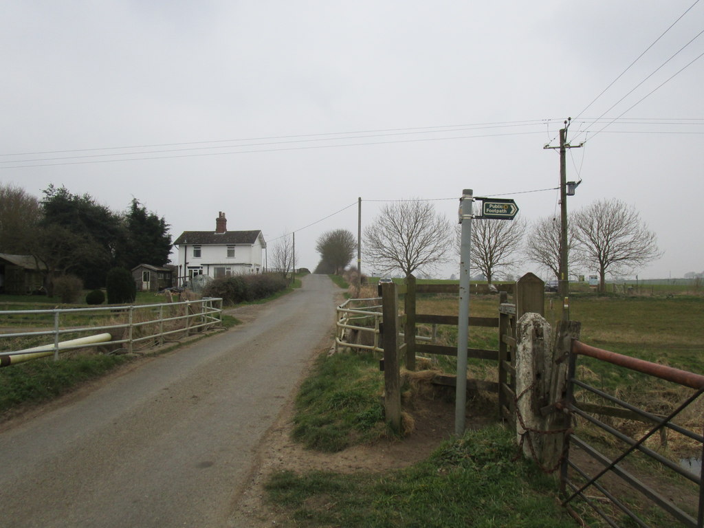 A country road with a Public Footpath sign leads to a farmhouse, illustrating the positive impact of giving and the helper's.